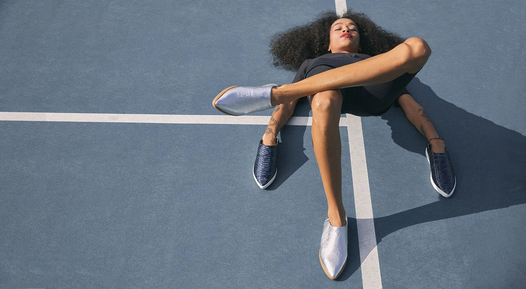Woman laying on tennis court with shoes